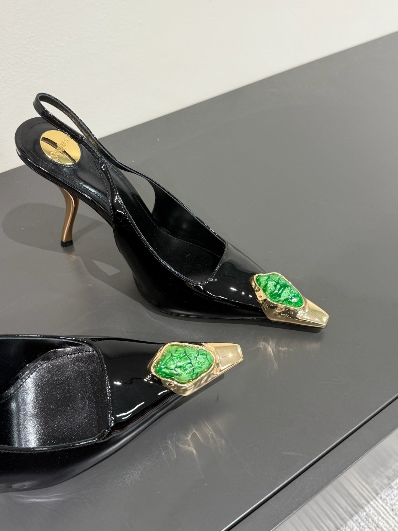 GREEN GEM-STUDDED SLINGBACK PUMPS IN BLACK PATENT CALFSKIN