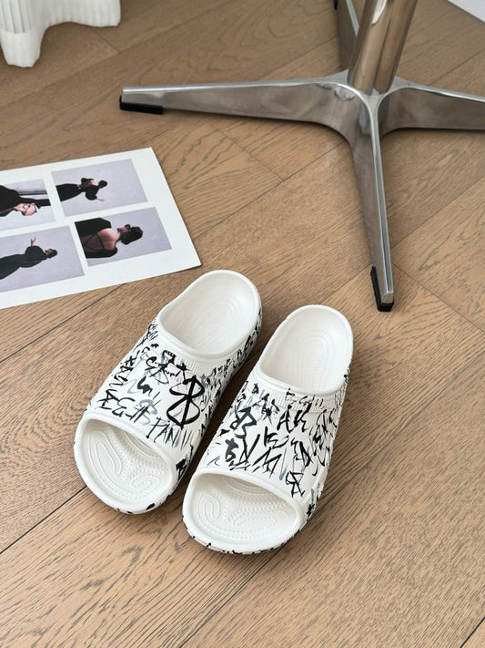 POOL GRAFFITI CROCS SLIDE SANDALS IN WHITE AND BLACK RUBBER