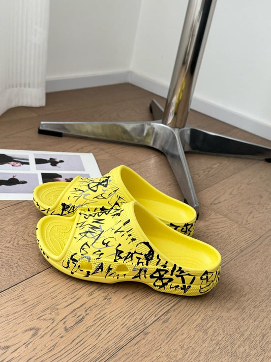 POOL GRAFFITI CROCS SLIDE SANDALS IN YELLOW AND BLACK RUBBER